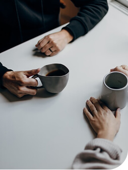 Two people socialising over a cup of coffee